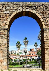 Buildings against blue sky seen through arch