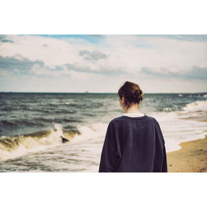 Rear view of woman looking at sea against sky