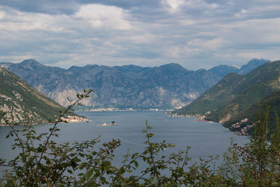 Scenic view of lake by mountains against sky