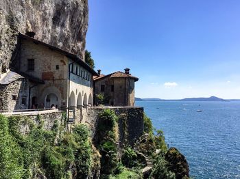 Building by sea against blue sky