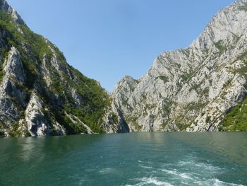 Scenic view of river and mountains against clear sky