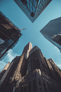 Low angle view of modern buildings against blue sky