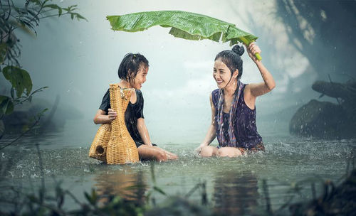 Rear view of woman with umbrella on water