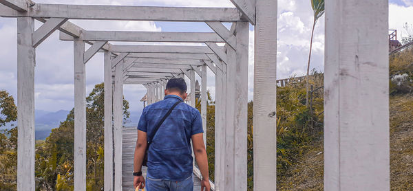 Rear view of man standing on bridge