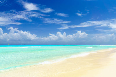 Scenic view of beach against blue sky