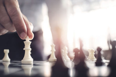 Midsection of man playing with chess against blurred background