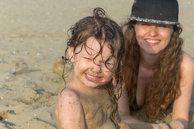 Portrait of smiling mother and daughter at beach