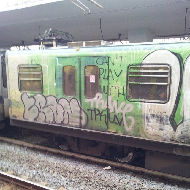 transportation, rail transportation, railroad track, public transportation, mode of transport, train - vehicle, graffiti, railroad station, railroad station platform, land vehicle, built structure, abandoned, train, passenger train, day, no people, indoors, architecture, green color