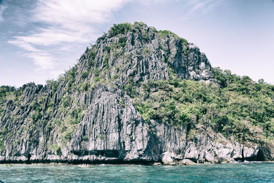 Scenic view of rock formation in sea against sky