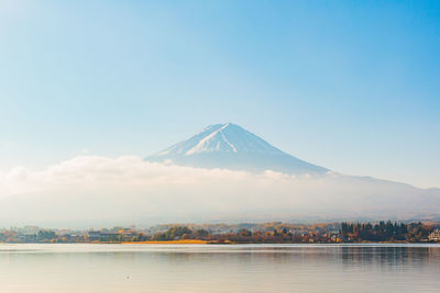 Scenic view of lake against snowcapped mountain during sunny day