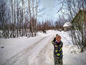 Grandson taking picture of moose