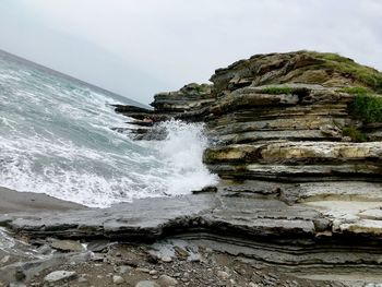 Scenic view of rocky beach against sky