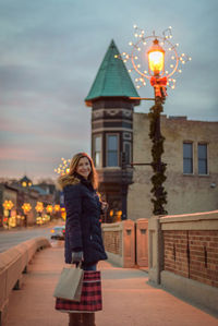 Rear view of woman walking on illuminated street light at night