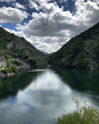 Scenic view of river amidst mountains against sky