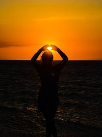 Man standing at beach during sunset