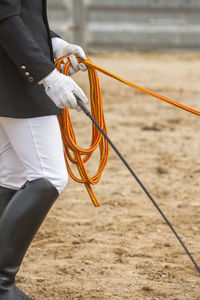 Midsection of man holding rope