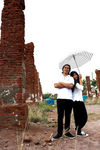 Full length of man standing against stone wall