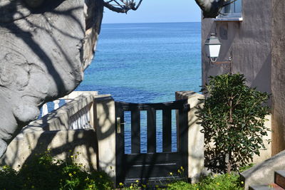 Built structure by sea against blue sky