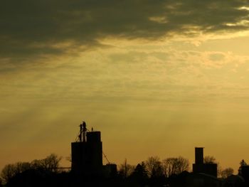 Low angle view of silhouette building against sunset sky