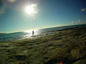 Scenic view of sea against bright sun