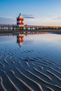 Scenic view of beach by sea against sky during sunset