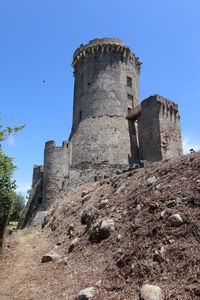 Low angle view of fort against clear blue sky