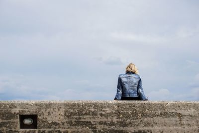 Rear view of woman standing against sky