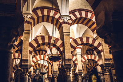 Low angle view of illuminated lstone arches in mezquita de cordoba