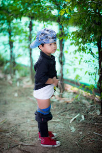 Boy looking away while standing on land