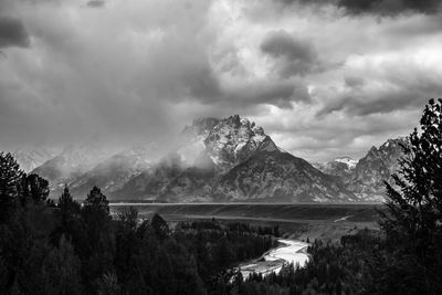 Scenic view of lake and mountains against cloudy sky