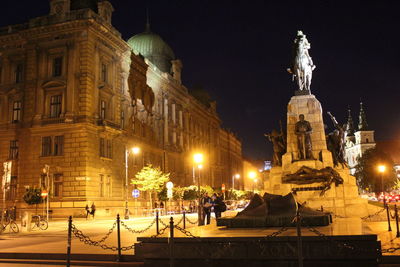 Statue in city at night