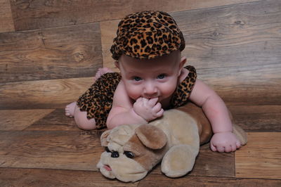 Close-up portrait of baby boy wearing costume on hardwood floor