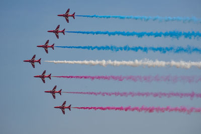 Low angle view of airshow against clear sky