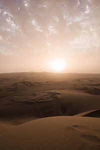 Scenic view of desert against sky during sunset