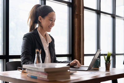 Businesswoman using mobile phone at table