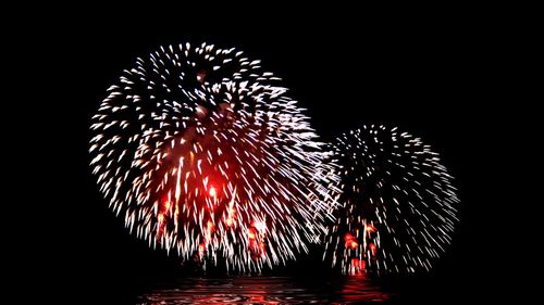 Firework display against sky at night