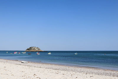 Scenic view of beach against clear blue sky