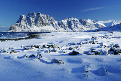 Scenic view of snowcapped mountains against blue sky