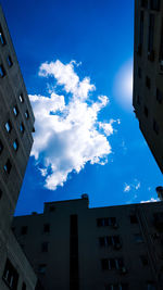 Low angle view of apartment buildings against blue sky