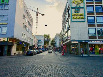 View of city street and buildings against sky