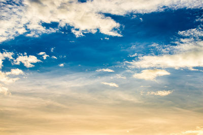 Low angle view of sunlight streaming through clouds