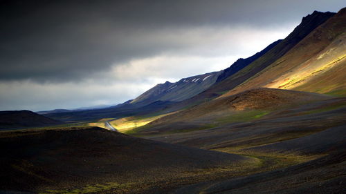 Scenic view of mountain range against cloudy sky