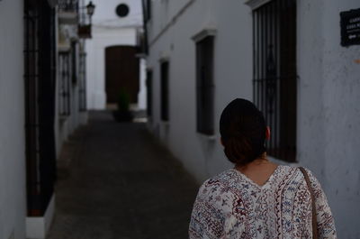 Rear view of woman walking on building