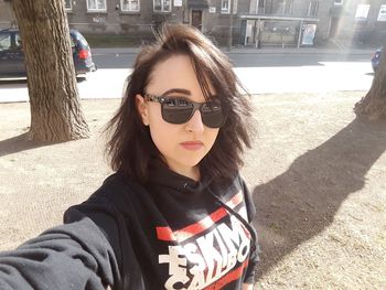 Portrait of man wearing sunglasses standing in city