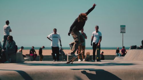 People jumping on street against clear sky in city