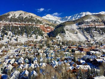 Aerial view of snowcapped mountains against blue sky