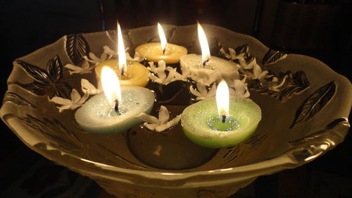 Close-up of lit candle in dark room