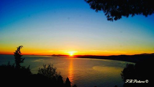 Scenic view of sea against clear sky during sunset