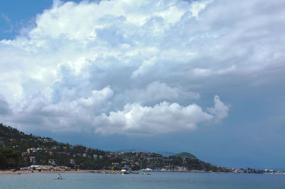 Scenic view of sea by city against sky