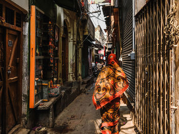 Man working on street amidst buildings in city